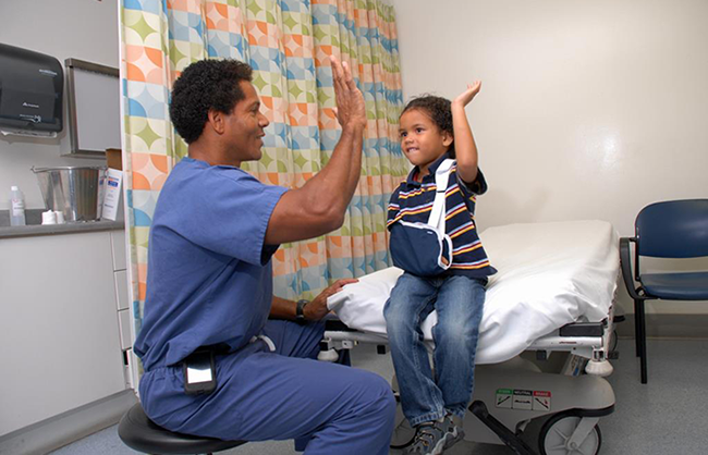 Orthopaedic Institute for Children doctor high-fives a a child with an arm sling