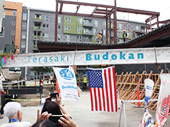 Construction workers raise a steel beam at a topping-off ceremony for the Terasaki Budokan in Little Tokyo (photo by Ichiro Shimizu)